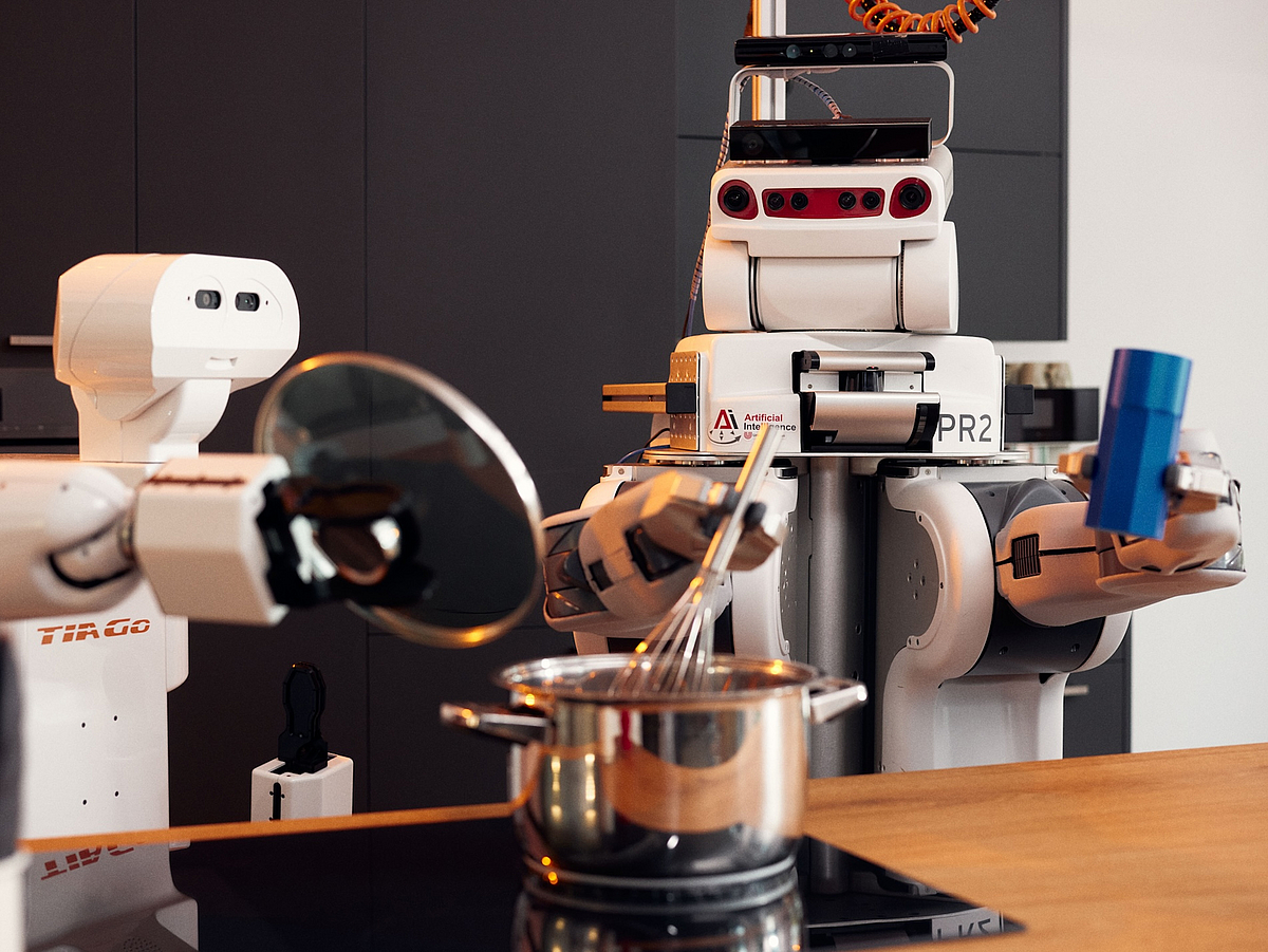 Two robots cooking together on one stove