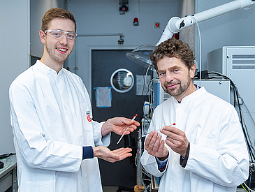 two researchers holding probes