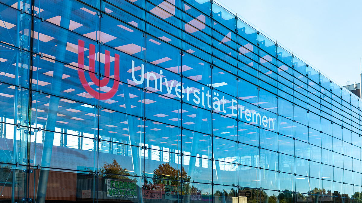 Die Fassade der Glashalle mit dem Logo der Universität.
