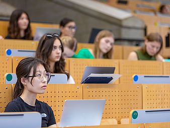 Studierende sitzen im Hörsaal bei einer Vorlesung