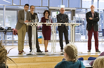 Vier Männer und eine Frau während einer Podiumsdiskussion