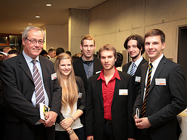 Gruppenbild mit älterer Mann und fünf Studierenden während einer Feier.