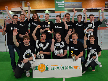 Group picture with football robots and their engineers