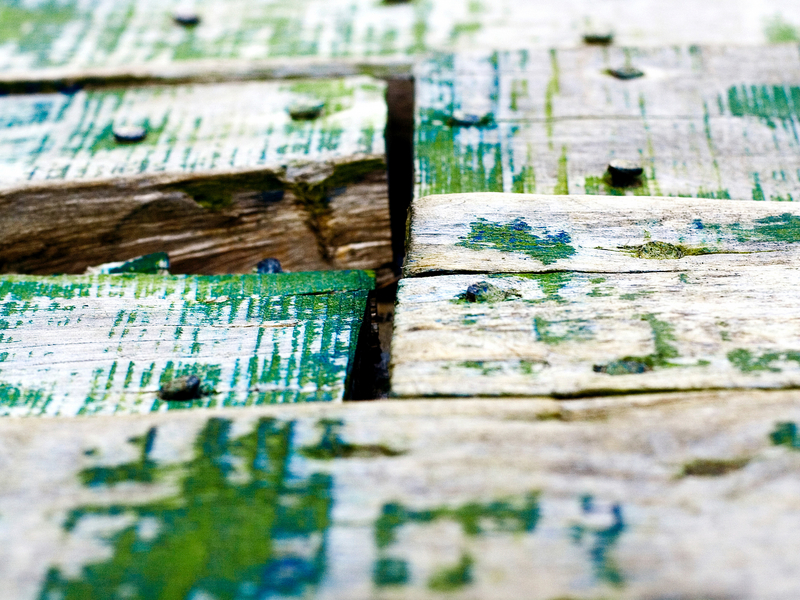 Holzsteg mit abblätternder grüner Farbe