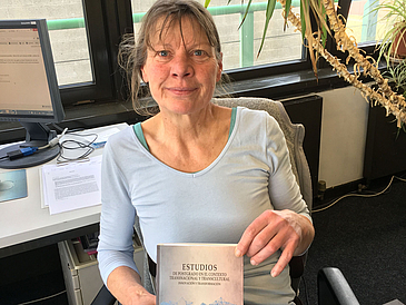 Frau im Büro mit Buch in der Hand