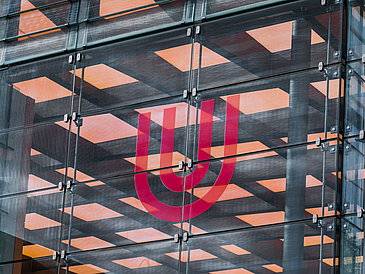 Logo der Universität auf der Glashalle.