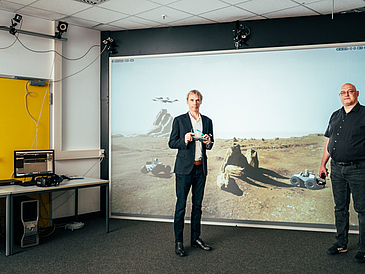 Am Technologie-Zentrum Informatik und Informationstechnik (TZI) der Universität Bremen arbeiten Professor Gabriel Zachmann (links), Leiter der Arbeitsgruppe Computergrafik, und René Weller, Koordinator der Initiative VaMEx, mit Robotern in virtueller Realität