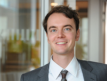 Man in suit smiling at the camera.