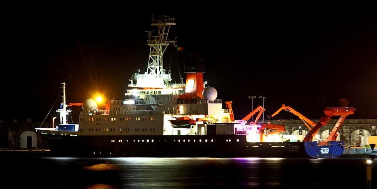 The research vessel Meteor lies in the harbor of Ponta Delgada at night, the decks are brightly lit.