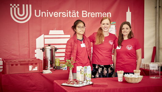 3 Frauen vor einem Uni Bremen Banner