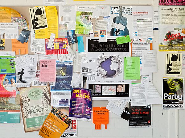 Eine Pinnwand voller Flyer.