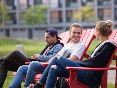Studierende auf Liegestühlen im Campuspark.