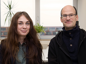 Junge Frau und junger Mann sitzen am Tisch