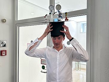 Simon is putting his graduate hat on his head