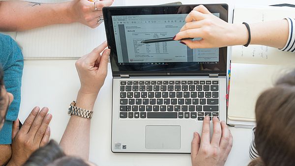 People work at a laptop.