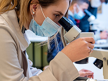 A school pupil working with a microscope.