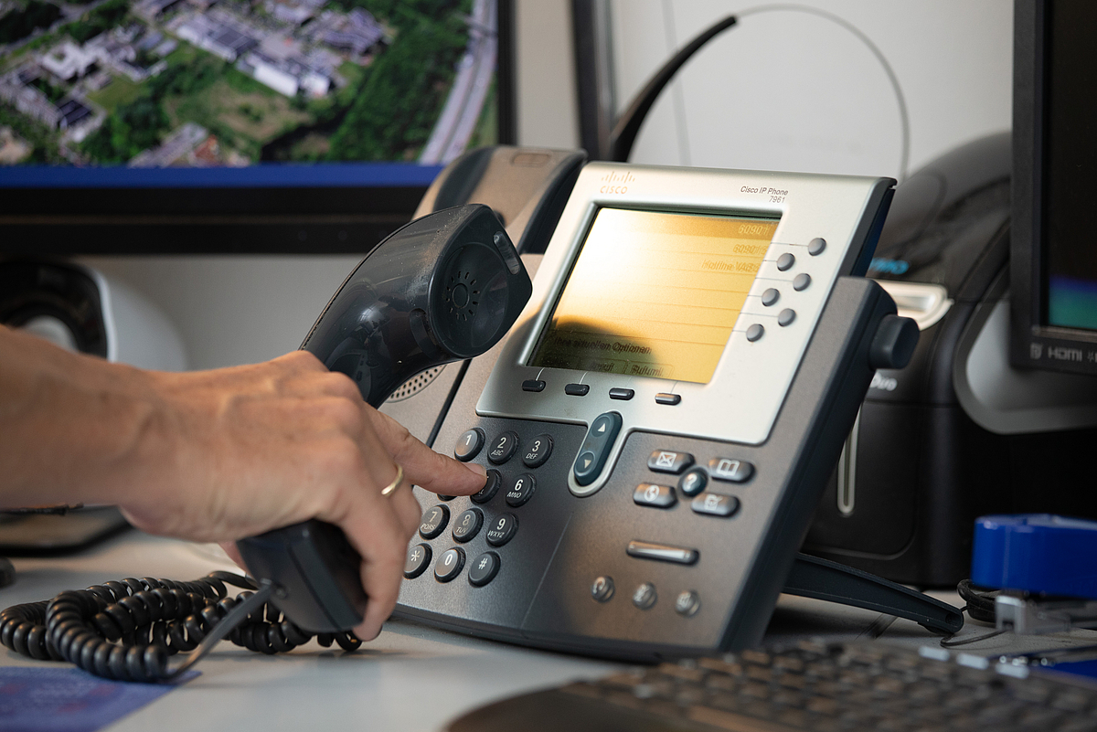 Kooperationen Eine Person bedient das Telefon.