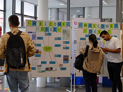 Studierende vor der Infotafel im VWG Foyer