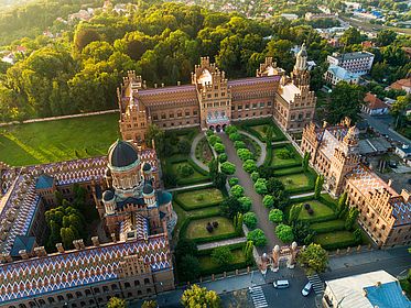 Aerial sunset view of Yury Fedkovych national University in Chernivtsi, Ukraine fedkovych, yurii fedkovych chernivtsi national university, czerniowce, roof, touristic, dalmatian, sights, metropolitans, sightseeing, bucovina, ukrainian, travel, historic, famous, architecture, europe, unesco, bukovina, tourism, ukraine, chernovtsy, old, landmark, building, historical, education, religion, chernivtsi, brick, national, exterior, university, city, history, heritage, campus, metropolitan, tower, orthodox, residence, czernowitz