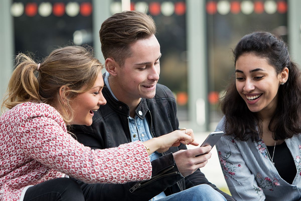 Studierende im Gespräch auf dem Universitäts-Boulevard.