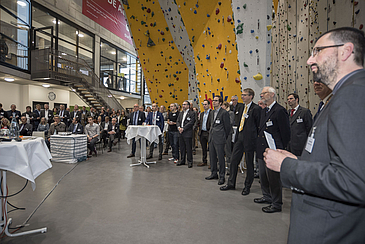 Gruppe von Menschen steht vor einer Kletterwand