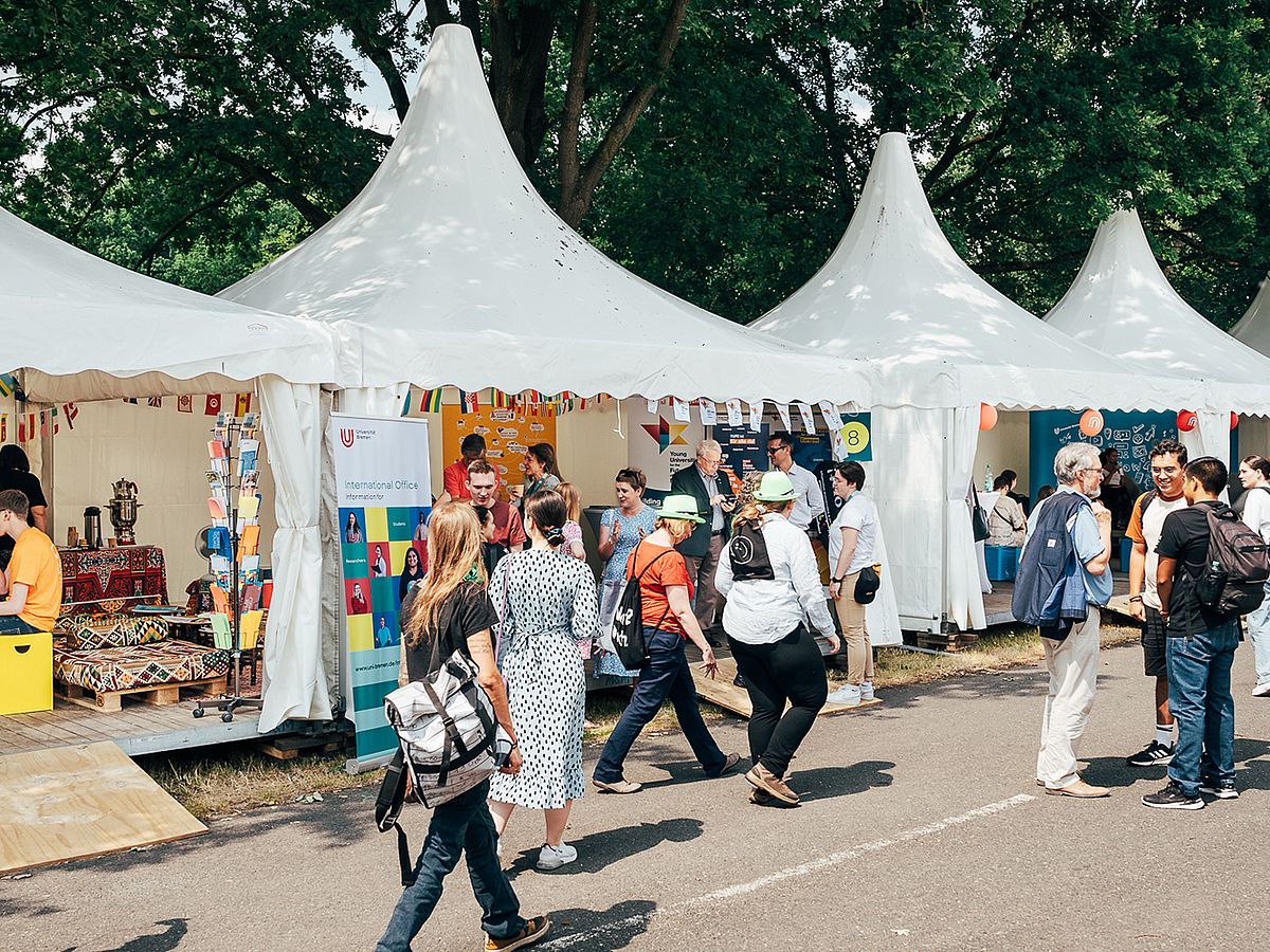 Menschen laufen zwischen den Padogen entlang.
