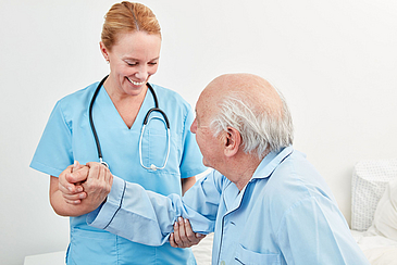 a nurse with a patient, holding his hand