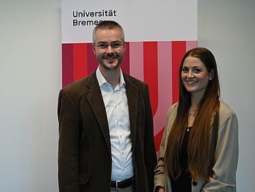 Prof. Paha und W. Siebert vor einem Banner der Universität Bremen