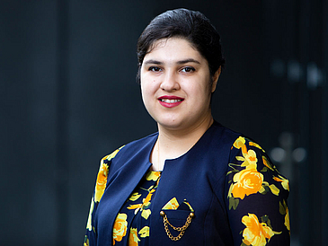 Portrait of a young woman in front of black background