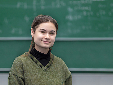 Adela Talipov, Frühstudentin an der Universität Bremen, steht vor einer Tafel in einem Hörsaal.