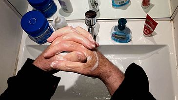 zwei Hände seifen sich über einem Waschbecken ein