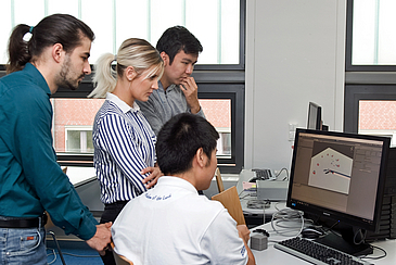 Vier junge Menschen an einem Computer