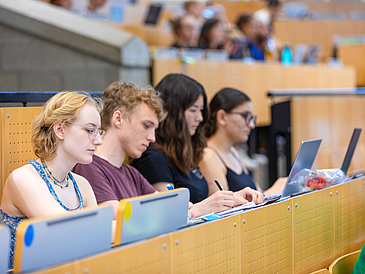 Studierende sitzen im Hörsaal bei einer Vorlesung