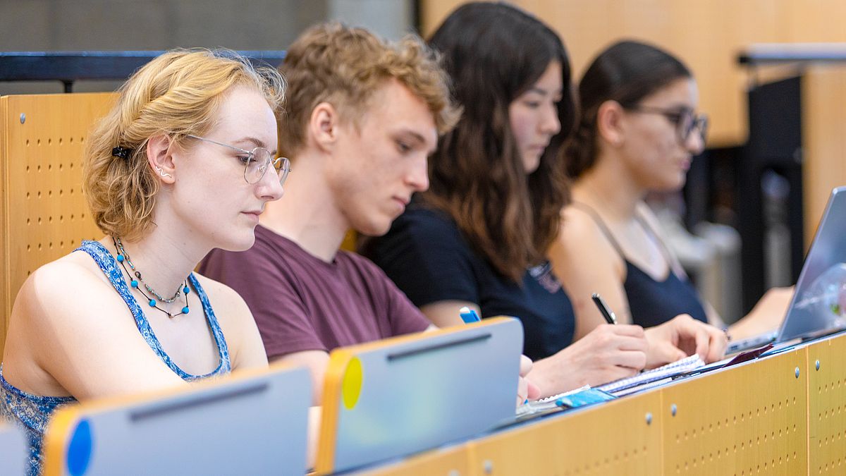 Studierende sitzen im Hörsaal bei einer Vorlesung