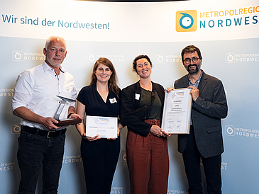 ruppenfoto mit Urkunde und Trophäe nach dem Gewinn des NordWest Awards 2024