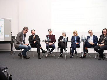 Foto des Podiums zum Thema “ Wie kann man nachhaltiges Forschen, Lehren, Lernen und Hochschulleben an den Hochschulen umsetzen?“ bei dem Vertreter*innen aus den Rektoraten, der Studierendenschaft, der Politik und dem Klimamanagement der Hochschulen anwesend waren, geleitet durch Jürgen Ritterhoff von Ecolo.