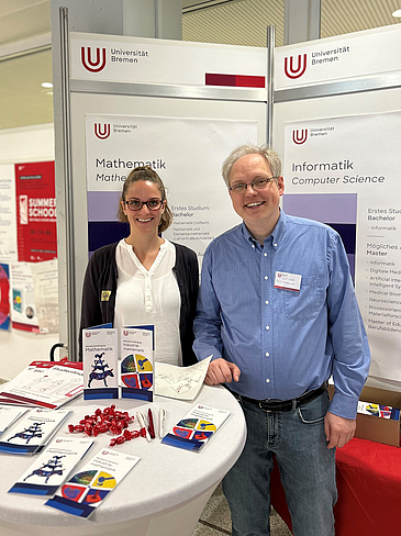 A Picture of Luisa Gunia and Professor Rademacher standing behind a desk with flyers and information