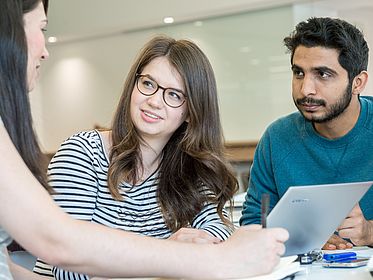 Junge Menschen arbeiten am Laptop.