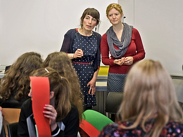 Zwei Frauen beobachten eine Gruppe