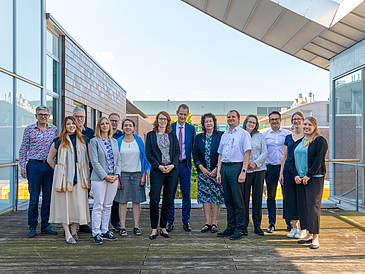 Die designierte Präsidentin Prof. Wendy Larner, Prorektor Prof. Rudolf Allemann, beide von der Cardiff University, die Konrektor:innen der Uni Bremen, Dr. Mandy Boehnke und Prof. Michal Kucera sowie Vertreter:innen der beiden Hochschulen stehen in einer Gruppe zusammen.