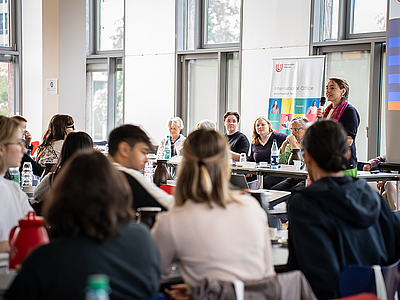 Frau Hasenmüller aus dem International Office spricht zu den Austauschstudierenden beim Begrüßungsfrühstück in der Mensa