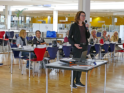 Frau sprich in das Mikro in der Mensa Uni Bremen