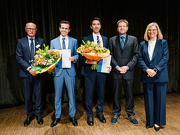 Zeigt mehrere Personen mit Blumen in der Hand