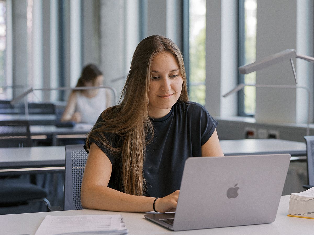 Studentin in Bereichsbibliothek WiWi schaut auf Laptop