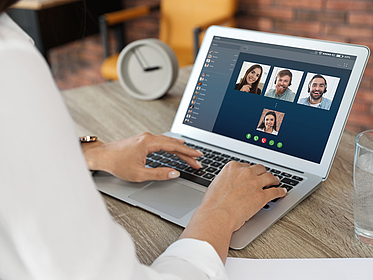 Frau vor dem Notebook sitzend in einer Videokonferenz Frau vor dem Notebook sitzend in einer Videokonferenz