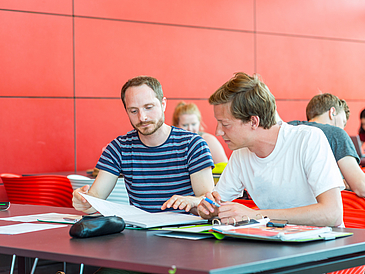 Studierende arbeiten am Tisch.