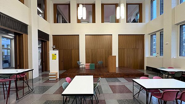 Banking Hall with a stage, tables and chairs.