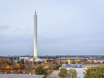 Ein Bild des Fallturm Bremen. Ein hoher weißer Turm auf dem Campus der Universität.