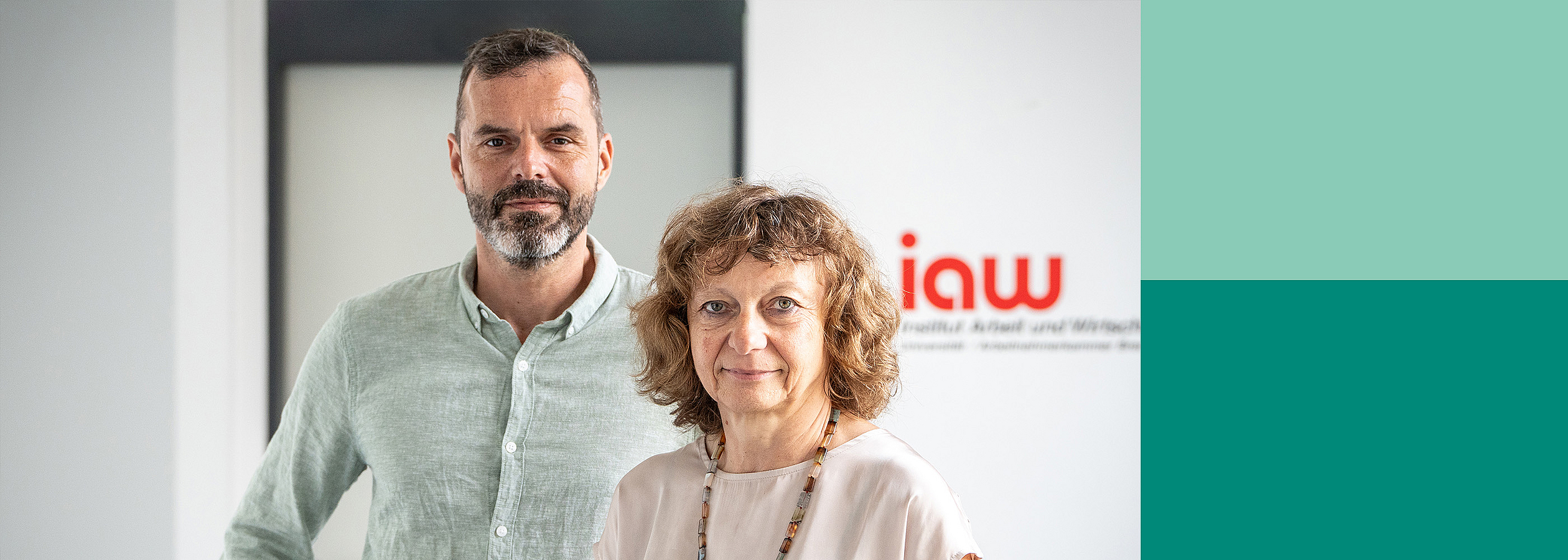 A man and a woman look into the camera