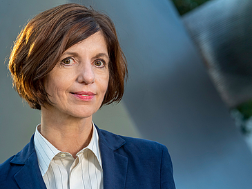 Portrait einer Frau mit kurzen braunen Haaren und blauem Jackett